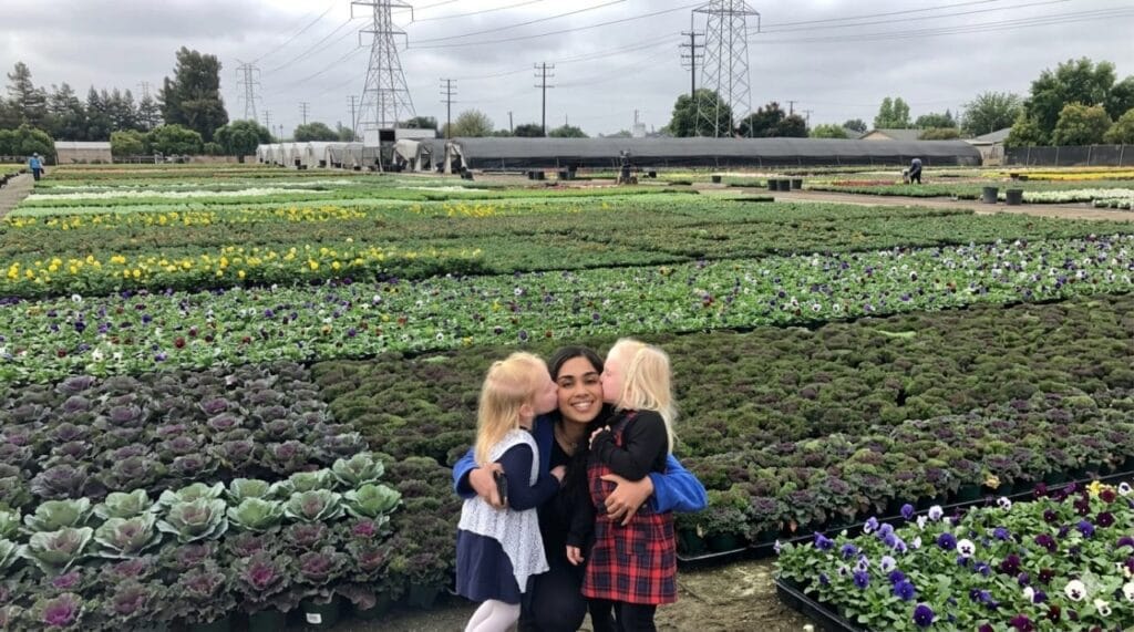 A Montessori teacher and young students at an outdoor plant nursery in Los Angeles, USA, demonstrating hands-on nature education